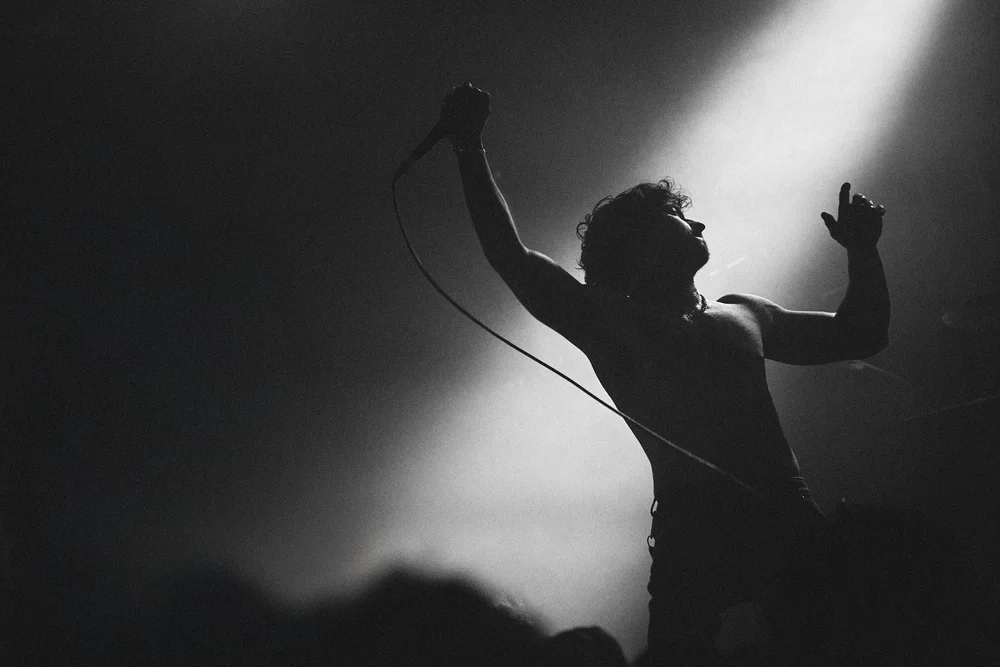 A musician holding a microphone during a live performance
